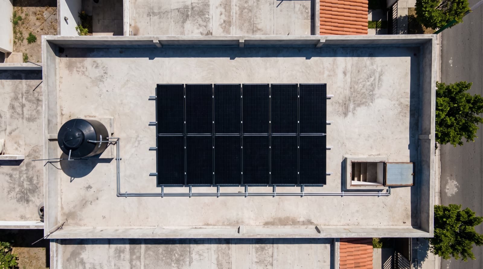 Vista aérea de una azotea con doce paneles solares en dos filas